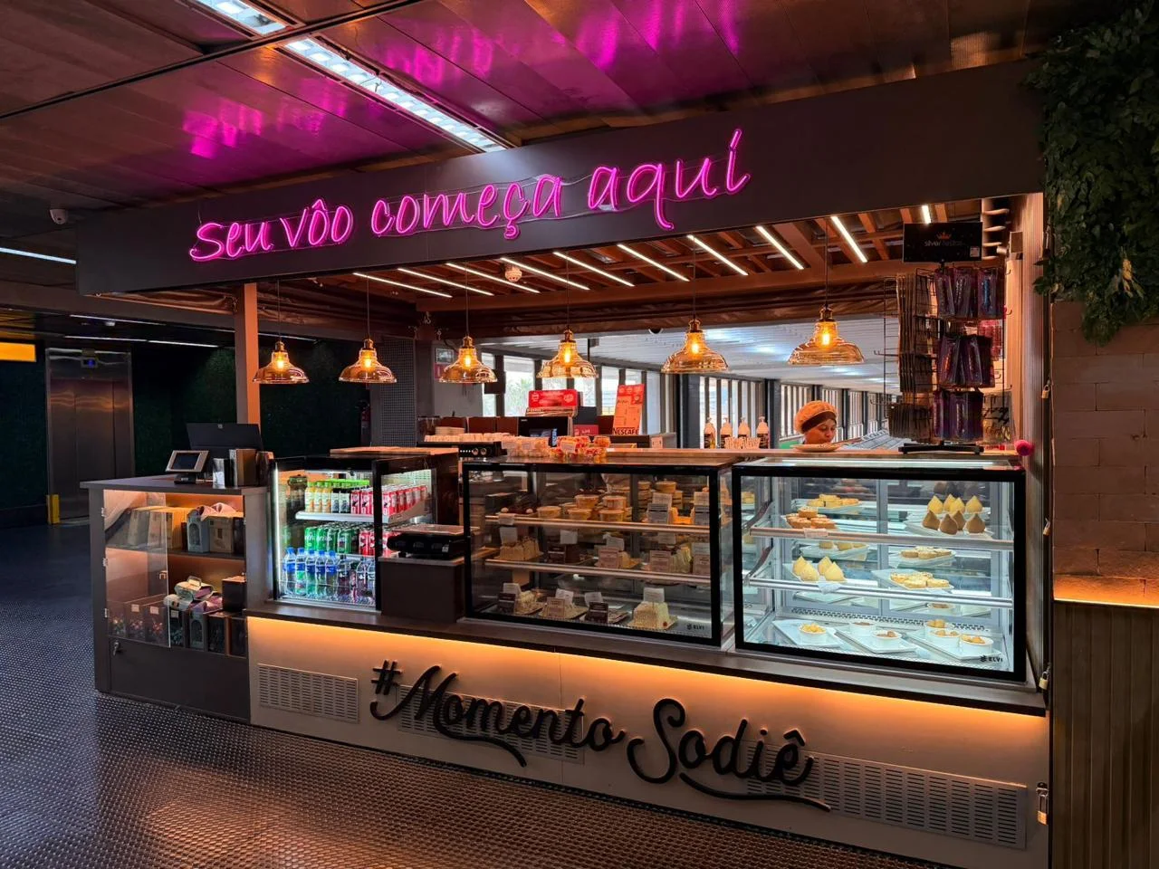 Sodiê Doces — operação aeroportuária com balcão, vitrines e comunicação em neon